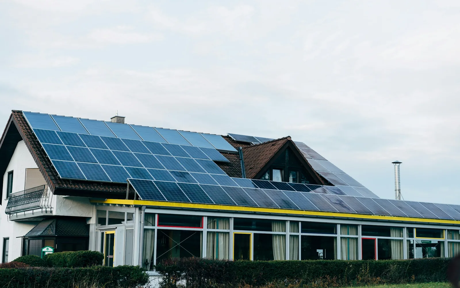 Weißes Wohnhaus mit großer Photovoltaikanlage auf dem Satteldach und verglastem Anbau (Markneukirchen, Vogtlandkreis)