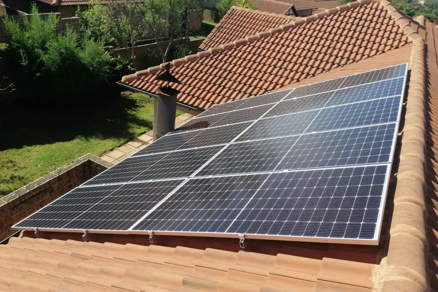 Photovoltaikmodule auf einem roten Ziegeldach neben einem Schornstein, Blick von oben (Kurl-Husen, Stadt Dortmund)